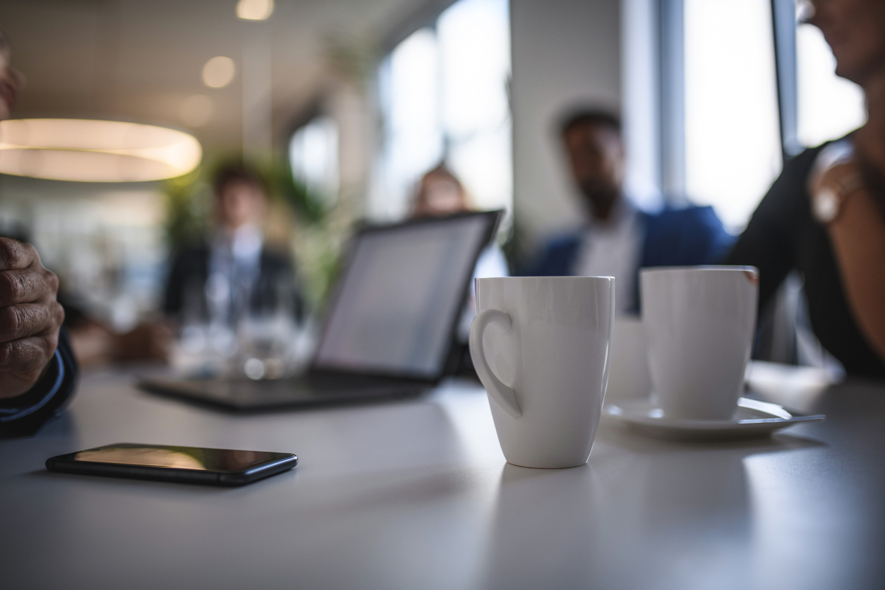 Coffee Mugs and Smart Phone on Conference Table